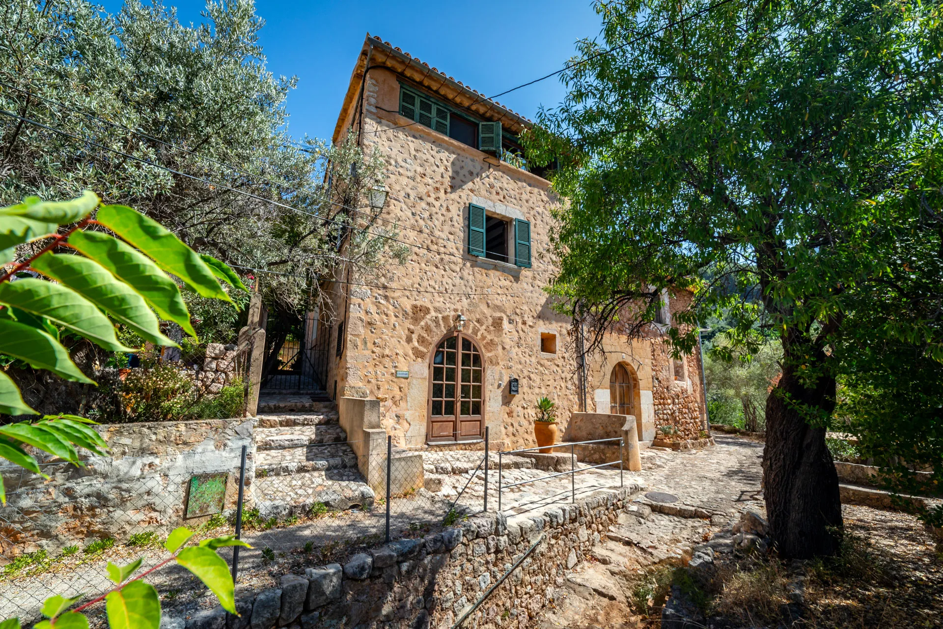 Traditional 3-story village house near Fornalutx with 3 bedrooms, rooftop office and stunning views. Features gardens, pool, guest house and potential for conversion or extension.